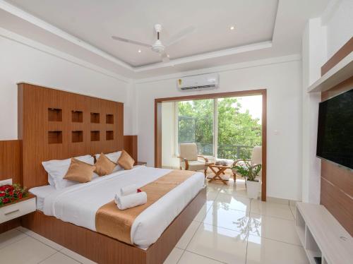 a bedroom with a large bed and a large window at Sprise Munnar Resort and Spa in Munnar