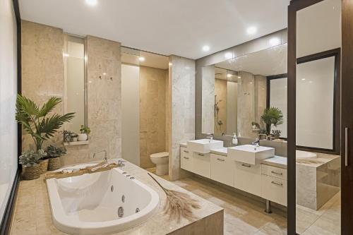 a large bathroom with two sinks and a tub at 119 Santai Resort - Poolside Apartment by uHoliday in Casuarina