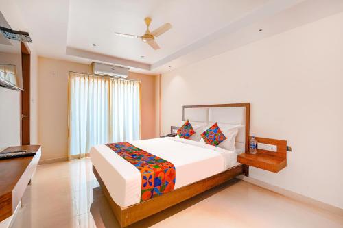 um quarto com uma cama grande e uma janela em FabHotel Phoenix Brookfield em Bangalore