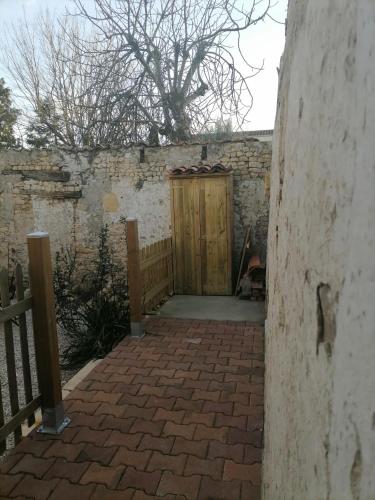 a wooden gate in a brick wall with a door at Studio 2 à 4 personnes in Dompierre-sur-Mer