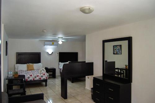 a living room with a bed and a television at Hotel del Alba Inn & Suites in Aguascalientes