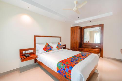 a bedroom with a large bed and a mirror at FabHotel Phoenix Brookfield in Bangalore