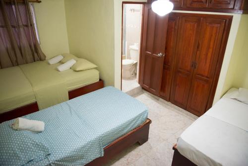 a small bedroom with two beds and a bathroom at Corales Del Sur Santo Domingo Este nearby Airport, Beach, Pool Water Park in La Viva