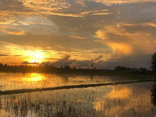 un tramonto su un corpo d'acqua di The Village Homestay a Siem Reap