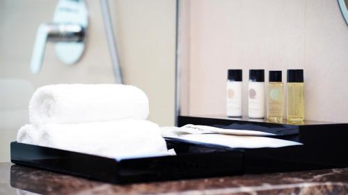 a bathroom counter with white towels and a mirror at Jasmine Garden Hotel in Jeddah