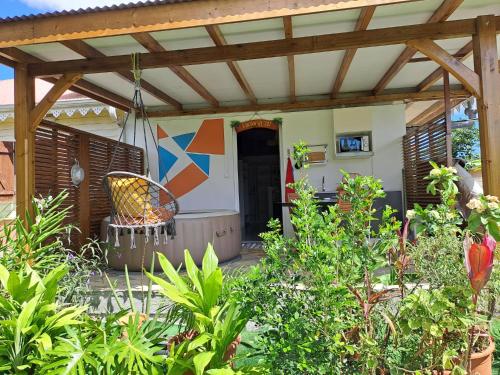 a patio with a pergola and a swing at La Poz Kreyol Appartement à la campagne in Le Lamentin
