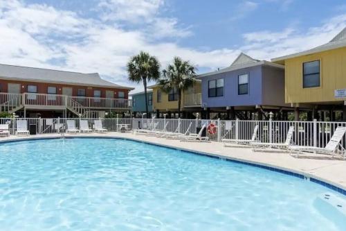 a swimming pool at a resort with chairs and condos at Ocean Breeze - Beautiful Condo & Pet Friendly in Gulf Shores