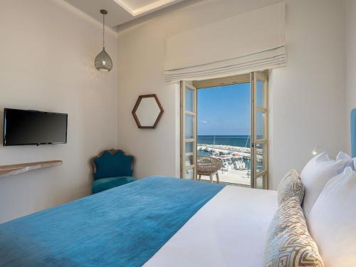 1 dormitorio con cama y vistas al océano en Avra Apartments Kolymbari Harbour, en Kolimvárion