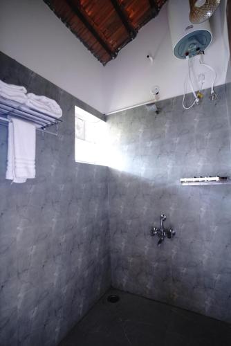 a bathroom with a shower with a sink at Ravishing Retreat Resort in Rāmanagaram