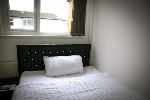 a bed in a bedroom with a pillow on it at Rostron House in Manchester