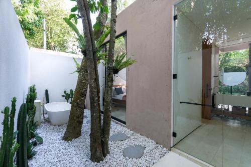 een badkamer met een boom in het midden bij Sealuna Villas in Tanah Lot