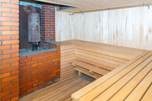 a sauna with a wooden bench next to a brick wall at Готель «На Кронштадській» in Avtozavodskiy Rayon