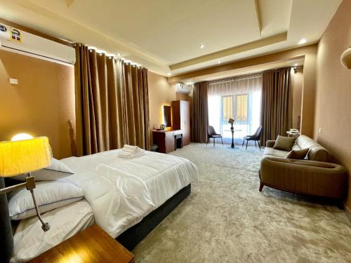 una camera d'albergo con letto, sedia e divano di Dahreez motel a Qurţah