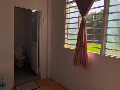 a bathroom with a window and a toilet in it at Hương Tràm in Hồ Ðá