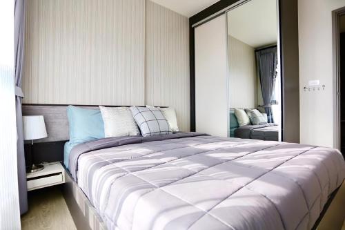 - une chambre avec un grand lit et un miroir dans l'établissement Central Pattaya Condo Best Pool & Great Location, à Pattaya