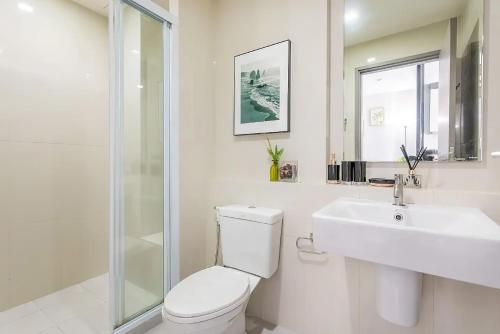 La salle de bains blanche est pourvue de toilettes et d'un lavabo. dans l'établissement Central Pattaya Condo Best Pool & Great Location, à Pattaya