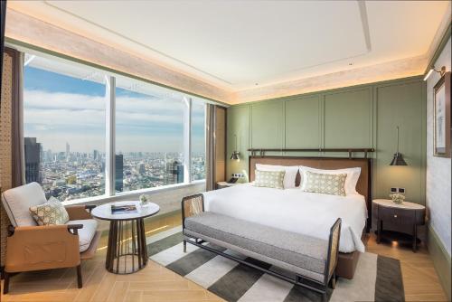 - une chambre avec un lit, une chaise et une grande fenêtre dans l'établissement Eastin Grand Hotel Phayathai, à Bangkok