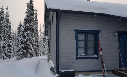 Una casa con nieve al costado. en Air-conditioned holiday home Vutnusmaja at Iso-Syöte, en Syöte