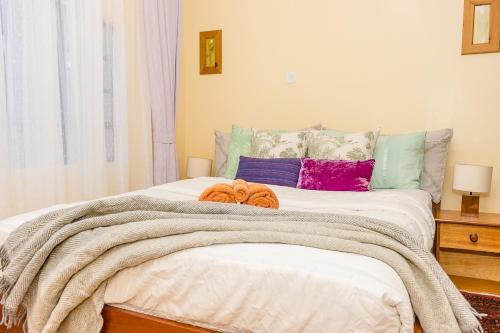 sypialnia z dużym łóżkiem z kolorowymi poduszkami w obiekcie Kenai Stay, Secluded 1 bedroom with free parking w mieście Nanyuki