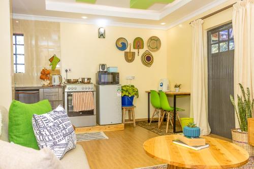 uma sala de estar com uma mesa e uma cozinha em Kenai Stay, Secluded 1 bedroom with free parking em Nanyuki