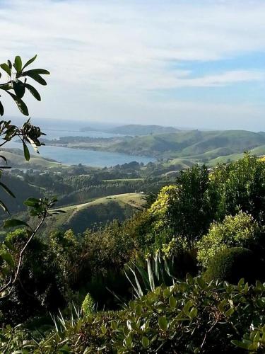 a view of a lake from the top of a hill at Otago Peninsula Paradise in Dunedin