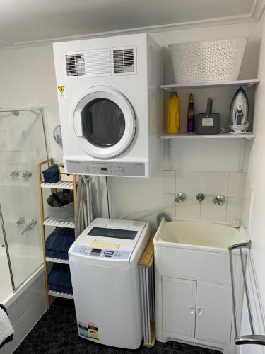 a small bathroom with a microwave and a washing machine at Sunshine Three in Salisbury