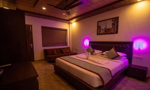 a bedroom with a large bed with purple lights at La Gracia Resort in Morjim