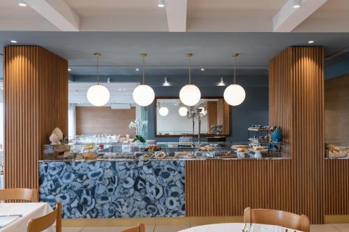 a kitchen with a bar with a counter top at Kiss Beachfront Hotel & Restaurant in Cervia