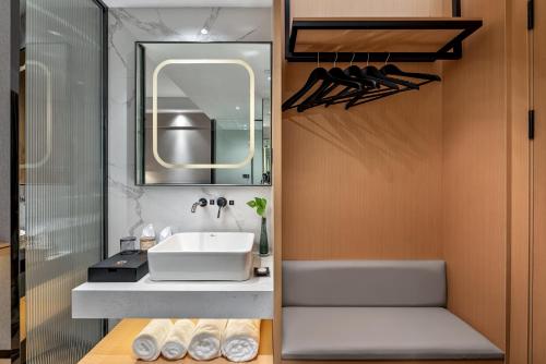a bathroom with a sink and a mirror at Jinshi Hotel in Guangzhou