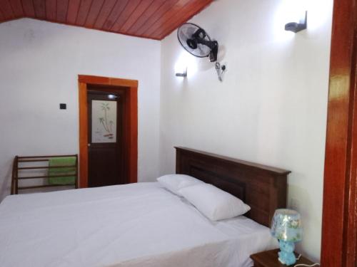 ミリッサにあるRainbow mountain villaの白いベッド1台(木製ヘッドボード付)が備わるベッドルーム1室が備わります。