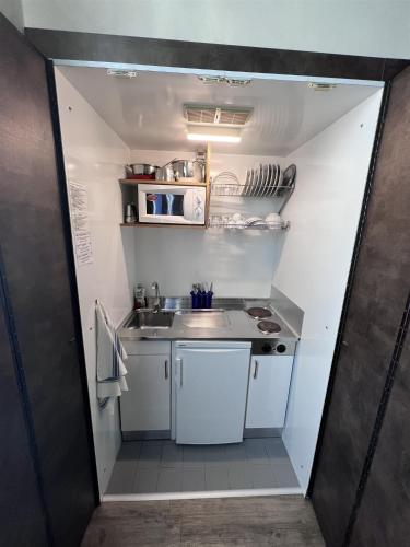a small kitchen with white cabinets and a sink at Residence Star in Turin