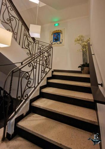 a set of stairs with a black railing at Hôtel Au Valéry in Sète