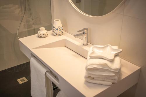 La salle de bains est pourvue d'un lavabo, d'un miroir et de serviettes. dans l'établissement Apartamento sobre el rio Guadiana, à Ayamonte