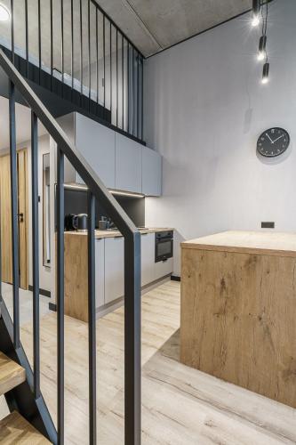 a kitchen and dining area with a staircase in a loft at RentPlanet - Apartamenty Zarembowicza II in Wrocław