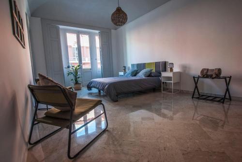 1 dormitorio con 1 cama y 1 silla en RossoPetruzzelli, en Bari