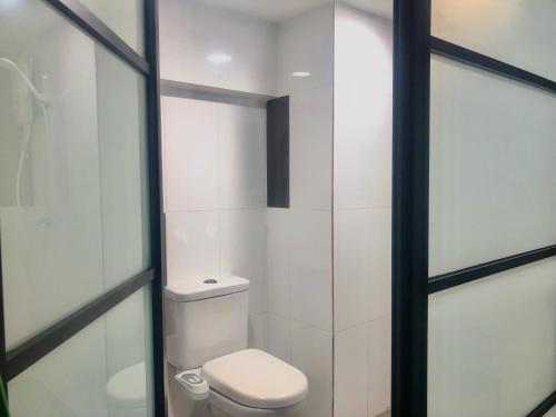 een badkamer met een toilet en een glazen deur bij Minimalist Boho Loft,2-6pax, The Curve, IKEA, Bandar Utama, Damansara in Petaling Jaya