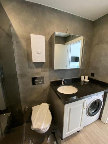 a bathroom with a sink and a washing machine at İSTANBUL BEACH HOTEL SWEET HOME in Kemer