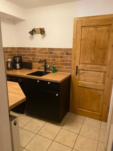 a kitchen with a sink and a wooden door at Ferienwohnung sentio-comfortable Saalfeld in Saalfeld