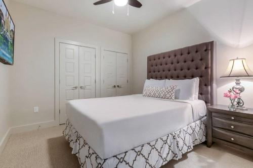 a white bedroom with a large bed and a lamp at Luxury 2BR/1BR in California Building in New Orleans