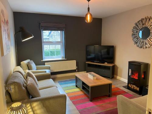 a living room with a couch and a tv at Column Mews Townhouse in Alnwick