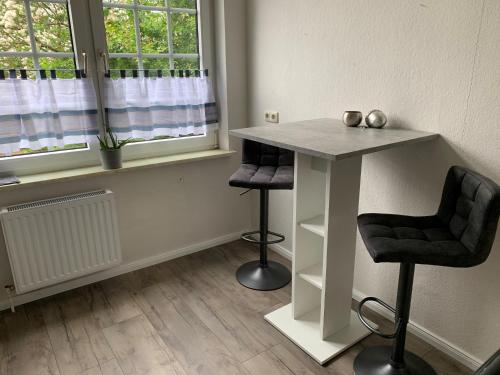 une chambre avec une table, deux chaises et une fenêtre dans l'établissement HeideZeit No 4, à Neuenkirchen