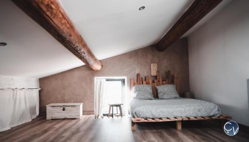 a bedroom with a bed with a wooden headboard at Mazet en pierre avec jardin privatif in Sernhac