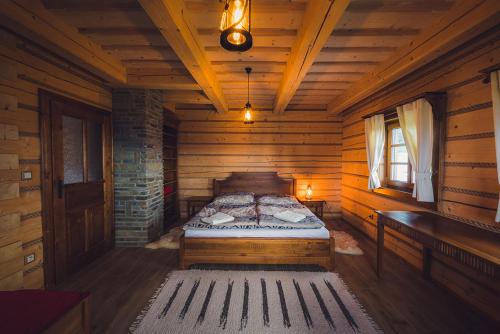 a bedroom with a bed in a wooden cabin at Koliba Holica in Huty