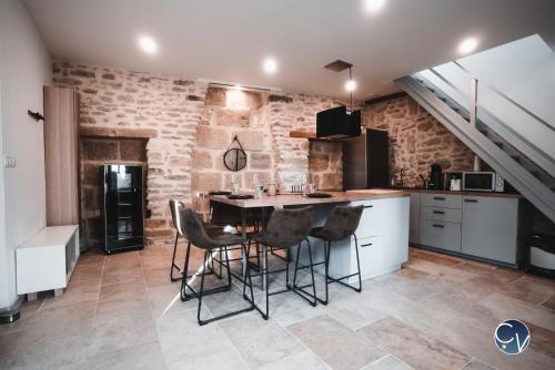 a kitchen with a table and chairs in a room at Mazet en pierre avec jardin privatif in Sernhac