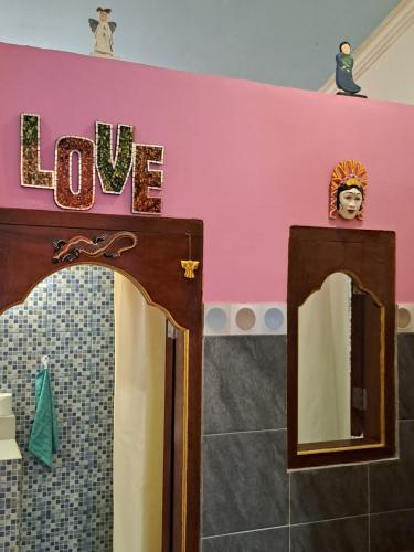 a bathroom with a mirror with the word love on the wall at Kubu Pilatus – Family House Lombok in Tjakranegara