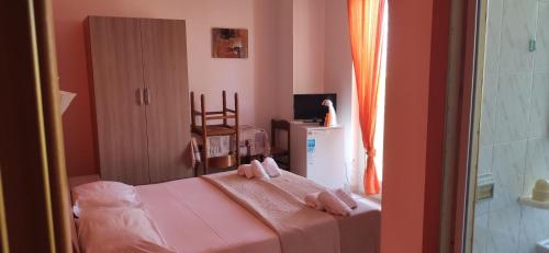 um pequeno quarto com uma cama com paredes cor-de-rosa em Appartamento Monolocale N3 Balcone a Briatico 2 Min dal mare e 15 min da Tropea em Briatico