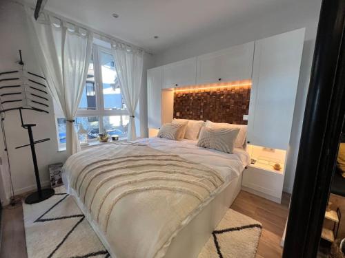 a bedroom with a large bed with a large window at Boutique lux design apartment @Bansko Royal Towers in Bansko