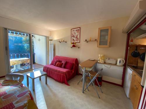 un salon avec un canapé rouge et une table dans l'établissement les goelands, à Saint-Georges-de-Didonne