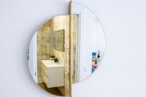 uma casa de banho com um lavatório e um espelho em The Kuuyi Suite no Burgau