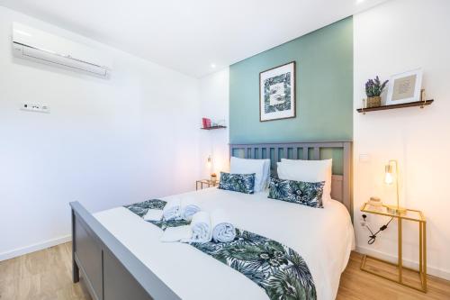um quarto com uma cama grande e uma parede azul em The Kuuyi Suite no Burgau